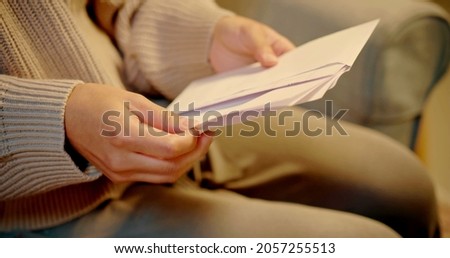 A woman is opening a letter Royalty-Free Stock Photo #2057255513