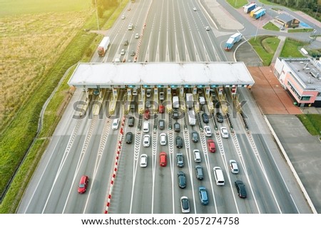 An overhead view of a busy toll road with many cars queuing up to pay the highway toll Royalty-Free Stock Photo #2057274758