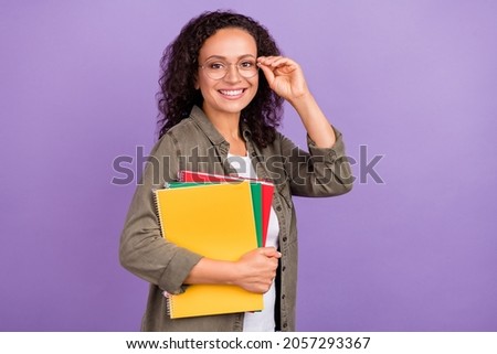 Photo of cheerful positive young afro american woman hold notebooks lecturer university isolated on purple color background