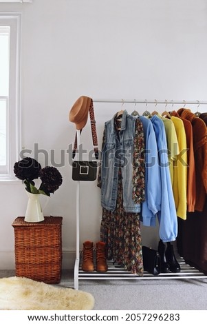 Rack with stylish women's clothes in the room. Interior design