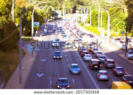 The movement of cars with lights on a road, highway. Blurred photo with the image of cars of different brands of top view. Speed, vehicle traffic at sunny spring or summer day. Big city life, energy. 