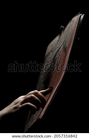 Artist drawing with fingers. Abstract hand painting on paper against black background.