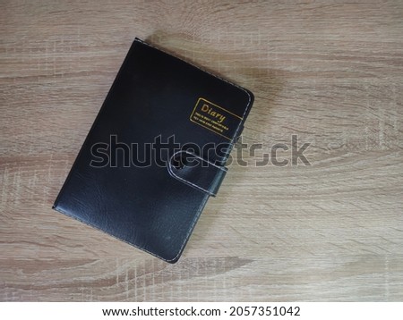 Black Diary Notebook on The Wood Table