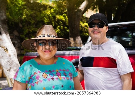 Latin couple smiling in the open air on colorful streets before getting into van