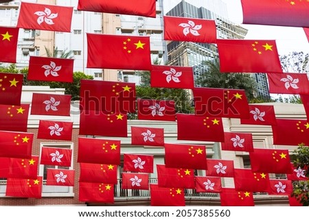 National flag of People’s republic of China and regional flag of Hong Kong Special Administrative region, hang in street and among buildings during national day