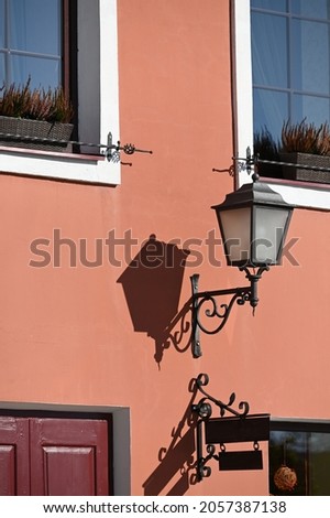 an outdoor light hung on the wall of a historic building