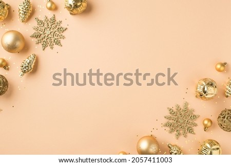 Top view photo of golden christmas tree decorations snowflakes cones balls and sequins in the corners on isolated beige background with copyspace