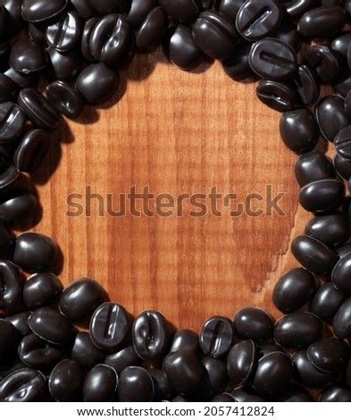 Coffee bean circular frame with a place for text on a natural wood background: a morning invigorating drink. Soft focus 