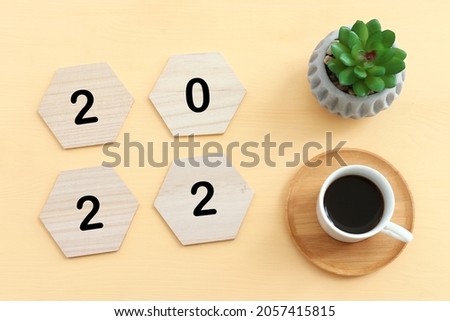 Top view image with wooden cubes with the text 2022 over yellow background