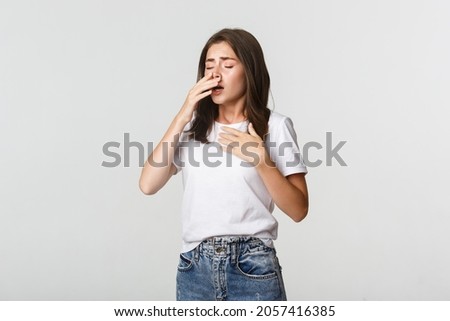 Young woman with allergy sneezing. Girl feeling sick having runny nose Royalty-Free Stock Photo #2057416385