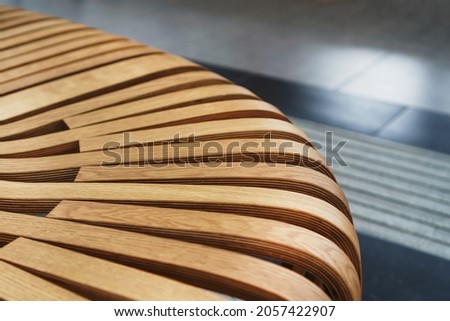 Modern curved wooden bench at the airport. Modern interior close-up Royalty-Free Stock Photo #2057422907