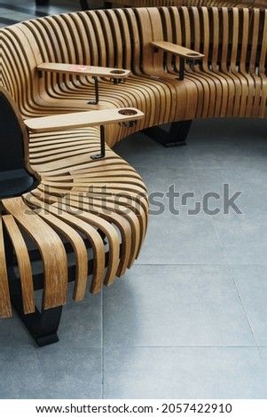 Modern curved wooden bench at the airport. Modern interior Royalty-Free Stock Photo #2057422910