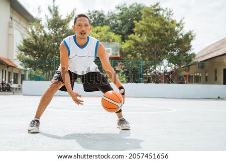 a male basketball player performs a low dribble with the ball while practicing basketball