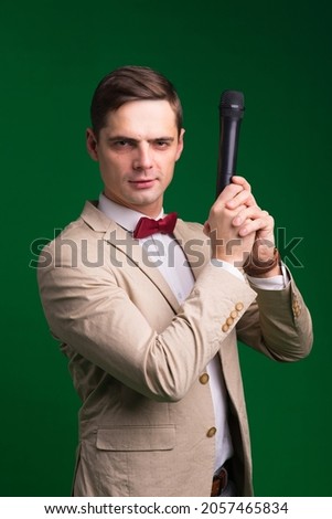 The entertainer. Young elegant talking man holding microphone, Isolated in a studio.