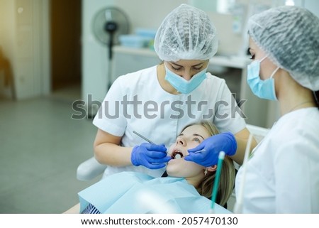 doctor dentist with an assistant make an examination in the patient's oral cavity in the dental office