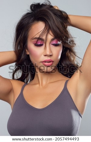 Beautiful brunet model woman face with brown eyes and perfect make-up . Portrait of beauty young brunet girl with pink lips. Female face with clear skin close-up. Skincare