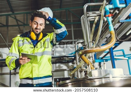 stress problem headache bad face expression hispanic engineer worker working in factory  Royalty-Free Stock Photo #2057508110