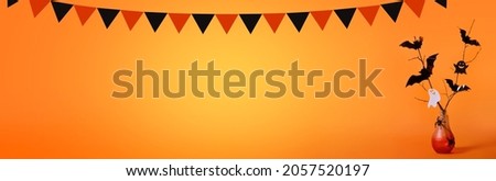 Halloween background with a red bottle in the form of a lamp, bats, spiders, ghosts, a garland in the form of black and orange flags on an orange background.Trick or treat. Banner. Copy space for text