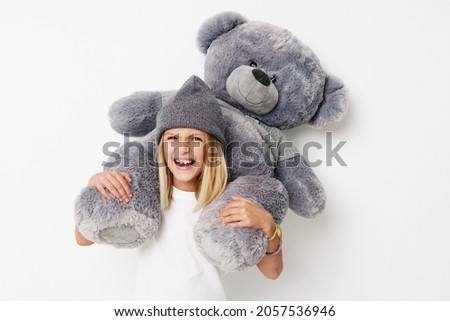 happy child teddy bear in the hands of fun on a light background