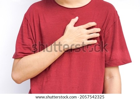 a young man hands holds his left chest, chest pain concept from Myocarditis or pericarditis caused by immune system,bacteria or viruses infection ,vaccination                              Royalty-Free Stock Photo #2057542325