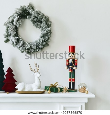 Christmas composition on the white chimney at the living room interior with beautiful decoration. Christmas tree and wreath, candles, stars, light. Copy space. Template.