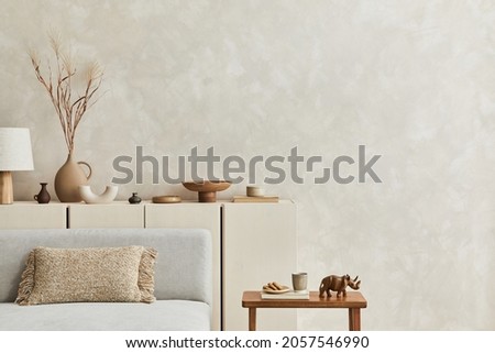 Creative composition of stylish living room interior with copy space, grey sofa, beige commode, clay vases and stylish personal accessories. Pastel neutral colours. Template. Royalty-Free Stock Photo #2057546990