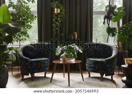 Extraordinary living room interior composition with two designed armchairs, wooden coffee tabqle, a lot of plants and stylish personal accessories. Urban jungle concept. Template.

