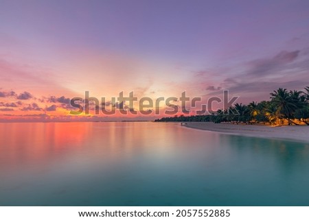 Beautiful bright sunset on a tropical paradise beach. Tranquil summer vacation or holiday landscape. Tropical sunset beach view with palm over calm sea water, Exotic nature view, inspirational scenic Royalty-Free Stock Photo #2057552885