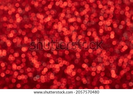Red sparkling glitter bokeh background, abstract defocused texture. Holiday lights