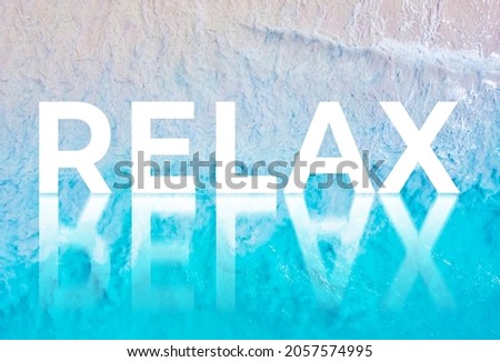 The word RELAX written by the ocean with a wave on the beach. Background for advertising