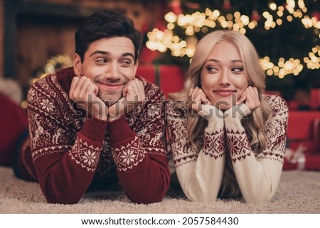 Photo of charming tricky wife husband dressed print pullovers celebrating noel smiling indoors room home house