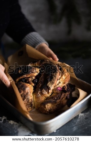 hands holding a sweet homemade bread on dark mood