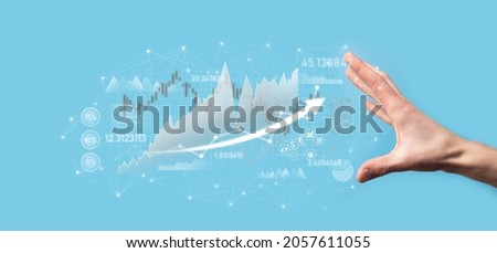 Businessman in hand hold banking business finance graph and invest in stock market investment point,economic growth and investor concept.analysis virtual stock market chart,analyze by use technology.