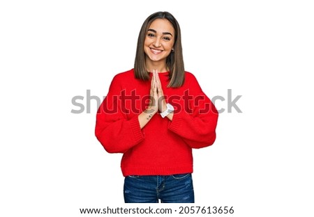 Beautiful brunette woman wearing casual winter sweater praying with hands together asking for forgiveness smiling confident. 