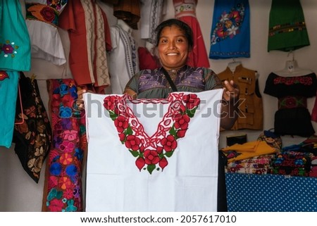 Mexican smiling at camera, mother working in regional clothing business