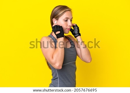 Young English woman isolated on yellow background listening music