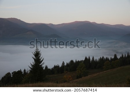 Picturesque view of mountains covered with fog in morning