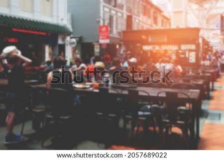 Blurred background of people and street food market with warm flare lights.