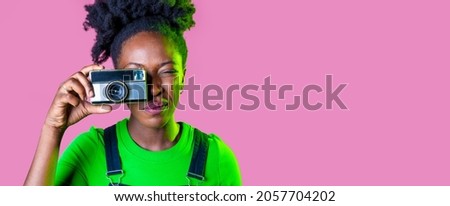 Young black woman isolated background taking photograph using vintage camera smiling happy and positive advertising copy space