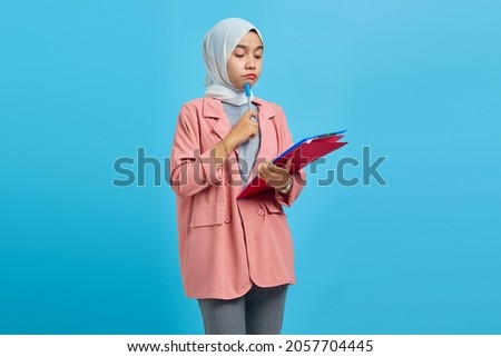 Young asian woman concentrated writing notes planning creating strategy over yellow background