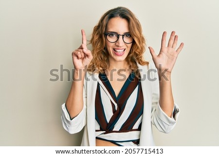 Young caucasian woman wearing business style and glasses showing and pointing up with fingers number six while smiling confident and happy. 