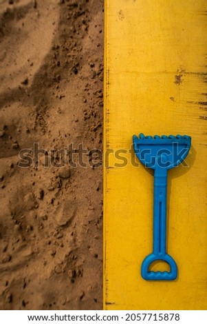 small children's rake lying on the sandbox. High quality photo