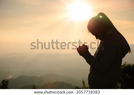 woman praying in the morning concept of christianity rising sun background Concept of prayer, faith, hope, love, liberation. Royalty-Free Stock Photo #2057718383