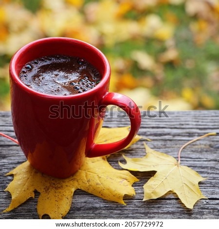 Autumn background. Blurred autumn leaves background with hot cup of coffee .