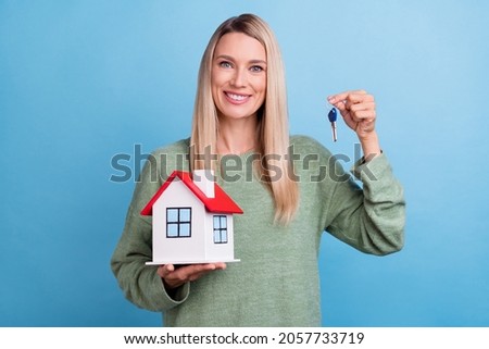 Photo of cheerful mature woman home key insurance accomodation loan isolated over blue color background