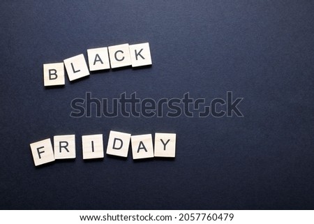 Top view of Black Friday super sale background with wooden letters on black paper. Black Friday concept with place for text.