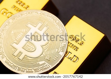 Macro photography is a Bitcoin coin lying on gold bars. The concept of the bitcoin and gold cryptocurrency financial market. Bitcoin is the coin of the future. Gold supports Bitcoin. Closeup. Top view
