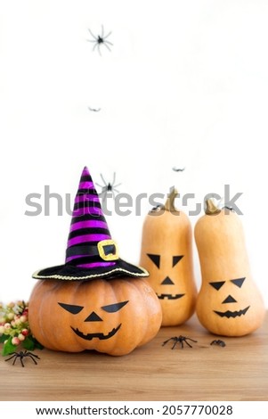 Jack o Lantern with witch hat, spiders, berries and Halloween squashes, vertical orientation