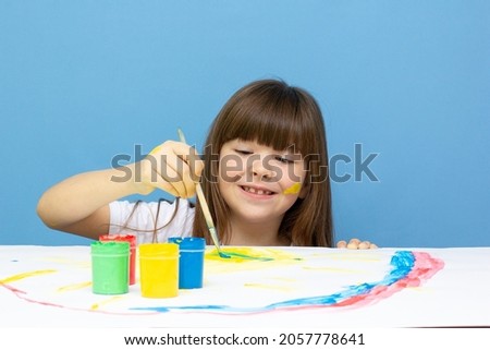 cute little girl with a brush and paints on a white background