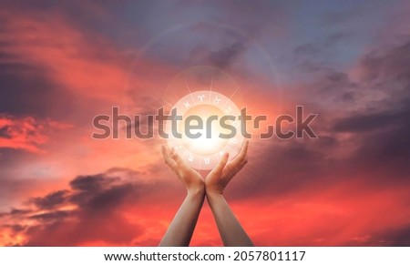 Zodiac signs inside of horoscope circle in woman hand at sunset. Astrology and horoscopes. Royalty-Free Stock Photo #2057801117